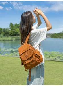 Gros plan extérieur d'un sac à dos en nylon orange-brun imperméable et léger avec logo