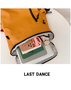 Detail of orange nylon backpack showing interior storage for laptop and school supplies