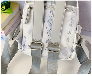 Detail of white backpack featuring butterfly print, ribbed fabric, and adjustable straps