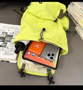 Großes Hauptfach des neonfarbenen Nylon-Rucksacks mit Tablet und Zubehör im Detail