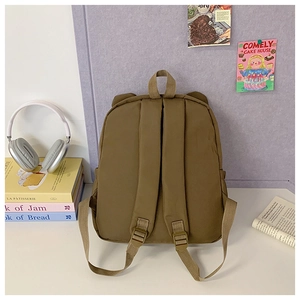 Detail view of khaki children backpack featuring adjustable shoulder straps and top handle
