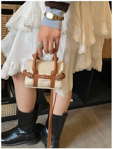 Détail du mini sac bandoulière en toile beige et cuir marron avec logo en métal