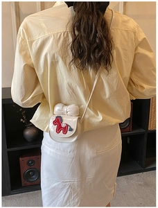 Détail du mini sac bandoulière matelassé avec broderie de cheval et nœud mignon