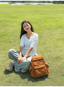 Gros plan du sac à dos en nylon avec logo circulaire et poches de rangement pratiques