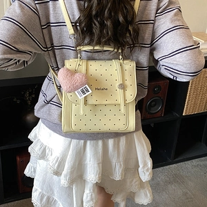 Pale yellow Korean style polka dot backpack with a cute pink plush heart charm