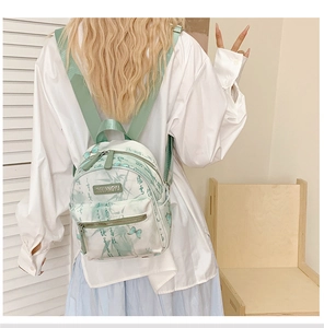 Detail of light green backpack featuring elegant bamboo and butterfly print patterns