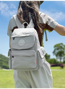 Photo de style de vie d'un sac à dos scolaire gris léger en nylon avec texture froissée