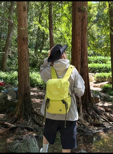 Detail eines neongrünen Outdoor-Rucksacks mit Schnallenverschluss und ergonomischen Gurten