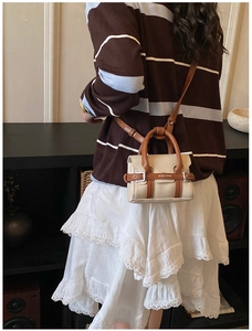 Vue arrière d'un enfant portant un sac à bandoulière vintage en toile et cuir marron
