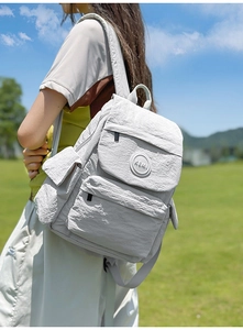 Vue extérieure d'un sac à dos léger gris clair avec tissu texturé et logo KEMI