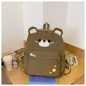 Close-up of cute brown bear canvas backpack showing embroidery and front pocket detail