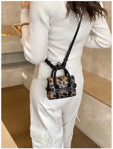 Détail du mini sac léopard avec poignées en cuir noir et bandoulière amovible
