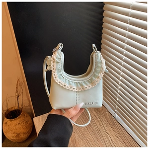 Close-up of light green children's mini bag featuring delicate lace trim and HELAHE text