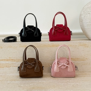 Mini crossbody square bags in four colors with bows and suede finish on stone steps