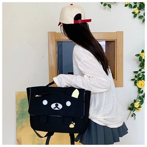 Detail view of large black canvas shoulder bag with cute cartoon bear face design
