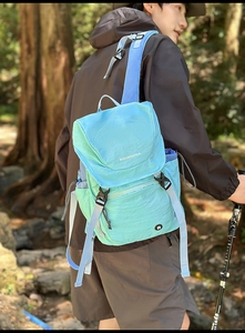 Detail eines hellblauen Outdoor-Rucksacks mit Schnallenverschluss und strukturiertem Stoff