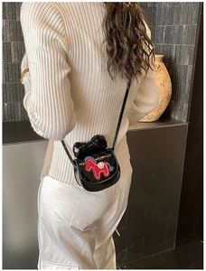 Détail du sac bandoulière matelassé noir avec gros nœud et broderie cheval