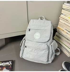 Détails du sac à dos en nylon gris clair avec texture froissée et plusieurs poches