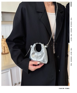 Silver metallic mini bag for kids with quilted texture and round handle on black suit