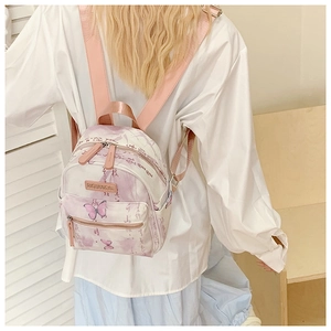 Close-up of mini backpack featuring pink butterfly print and calligraphy details