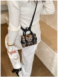 Gros plan du mini sac à main léopard avec boucles métalliques et crochets de sangle