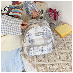Detail of off-white mini backpack with butterfly patterns and Chinese calligraphy