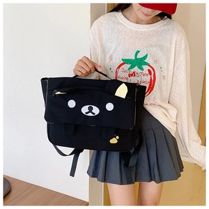 Detail of the cute black bear face embroidery and paw prints on the canvas backpack