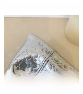 Close-up of metallic silver mini bag showing circular embossed texture and top handle
