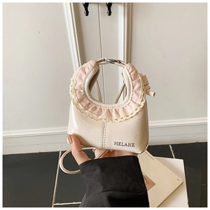 Detail of cream white leather bag featuring pink lace trim handles and HELAHE branding