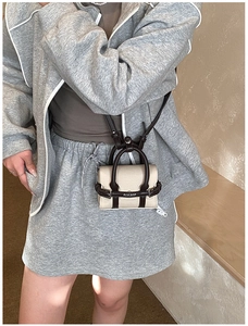 Détail du mini sac bandoulière en toile avec finitions en cuir marron et bandoulière