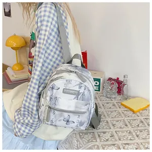 Detailed view of mini backpack featuring butterfly prints and artistic calligraphy texture