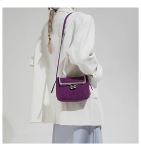 Detail of purple vintage kiss-lock crossbody bag with silver frame on model