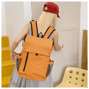 Rear view of vibrant orange waterproof backpack with flap cover and metal buttons