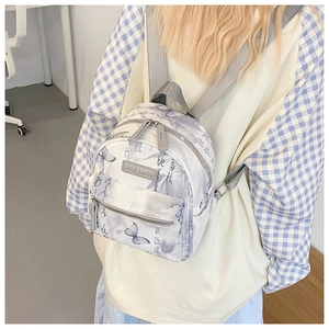 Detail of canvas backpack with artistic butterfly print and leather brand label