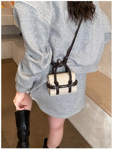 Vue latérale d'un sac bandoulière enfant en toile beige avec bordure en cuir marron