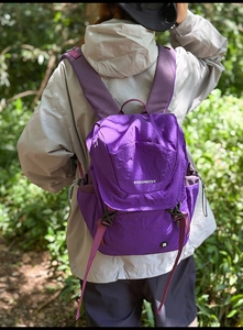 Outdoor-Ansicht eines violetten Nylonrucksacks mit Kordelzug-Seitentaschen