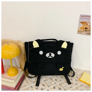 Detail of cute bear face design on black canvas school backpack with high-quality embroidery
