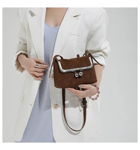 Sac bandoulière rétro marron avec fermoir à baiser et blazer blanc élégant