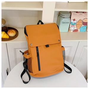 Detail of yellow kids backpack with magnetic buckles and black zipper on shelf