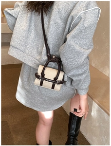 Détail d'un mini sac bandoulière en toile beige et cuir marron avec logo lettré