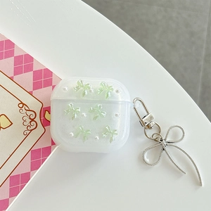Glittery AirPods case with green 3D bows, white pearls, and a silver bow pendant detail