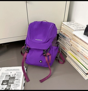 Detailansicht eines lila Kinderrucksacks mit Schnallenklappe und seitlicher Kordeltasche