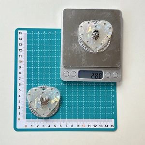 Détail du support de téléphone en forme de cœur avec strass et texture nacrée fine
