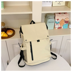 Detail view of cream-colored kids backpack with metal buckles and mesh side pocket