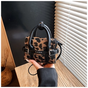Vue détaillée du mini sac léopard pour enfant avec poignées et bandoulière en cuir noir