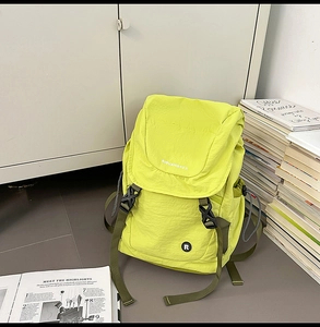 Detailansicht des neongrünen Rucksacks mit großer Klappe und schwarzen Schnallenriemen