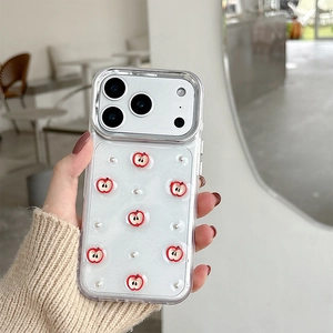 Close-up of clear iPhone case with 3D red apple decor held in a hand