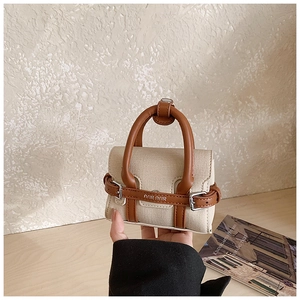 Détail du mini sac en toile avec lanières léopard, accents en similicuir brun et boucle métal