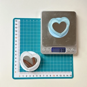 Macro view of heart-shaped phone mirror stand showing size 5.5cm and weight 37.8g