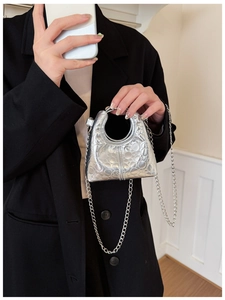 Detail of silver metallic mini bag featuring heart quilting and silver chain strap